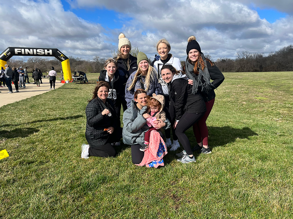 group of caucasian women in winter gear near the finish line of a 5K