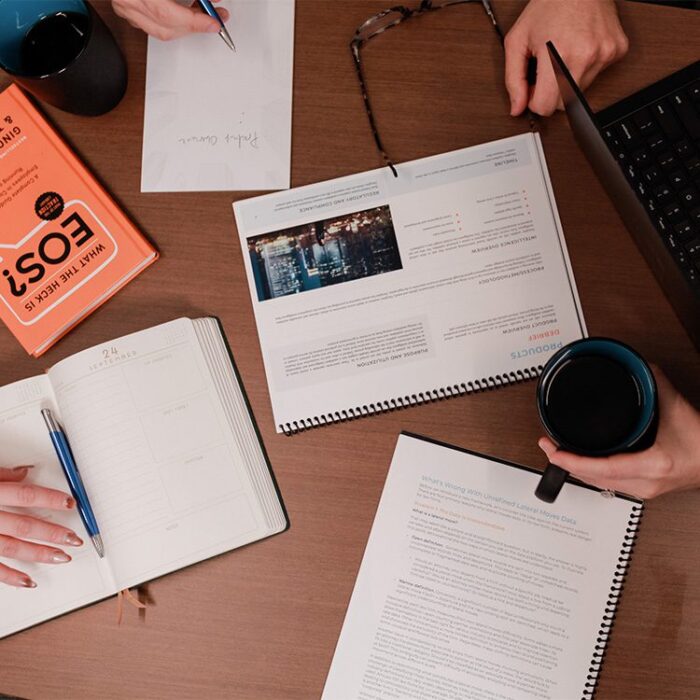 Aerial view of Decipher Intelligence employees' laptops and notes in a meeting