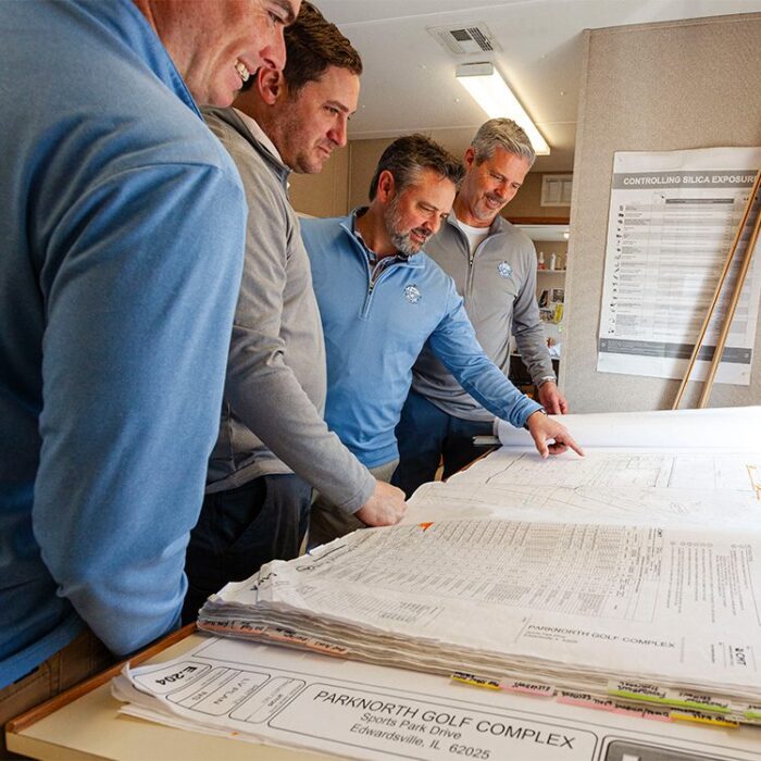Group of men reviewing construction plans for Park North Golf Club